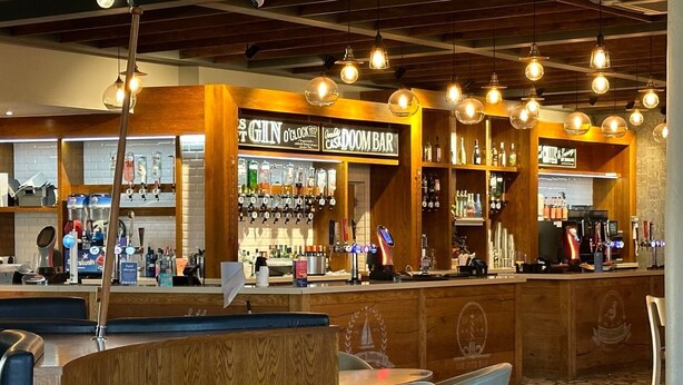 A bar area with wooden counters, seating, and hanging light fixtures. - Sea Breeze-A Beautiful 3 Bed,Pet Friendly Retreat (Mablethorpe)