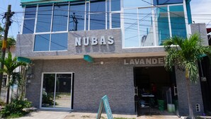 A building with a sign 'NUBAS' and 'LAVANDE' indicating a business establishment. - Hotel NB aeropuerto (Puerto Vallarta)