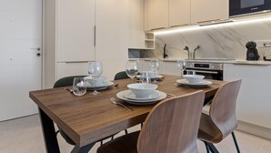 A modern kitchen with a dining area, equipped with a Bosch microwave, a coffee machine, and a marble countertop. - La Joya 1A. New apartment with Garage, 300 m from the beach (Torremolinos)