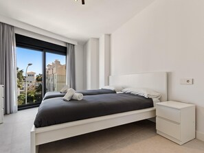A modern bedroom with a large bed, a nightstand, and a view of the cityscape. - La Joya 1A. New apartment with Garage, 300 m from the beach (Torremolinos)