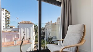 A room with a large window, a chair, and a view of buildings. - La Joya 1A. New apartment with Garage, 300 m from the beach (Torremolinos)