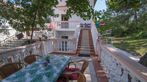 A patio with a table and chairs, a staircase, and a railing. - Holiday Apartment Zeljka A2 (Mali Lošinj)