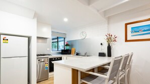 Una cocina moderna con una isla integrada, electrodomésticos de acero inoxidable y un ventanal grande.