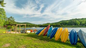 A lakeside setting with a gazebo and a row of kayaks.