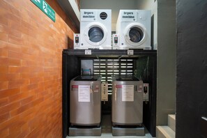 A laundry facility with two dryers and two washing machines. - Dent Station Residence (Chalong)