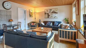 Ein Wohnzimmer mit Sofa, Couchtisch und einem Gemälde an der Wand.