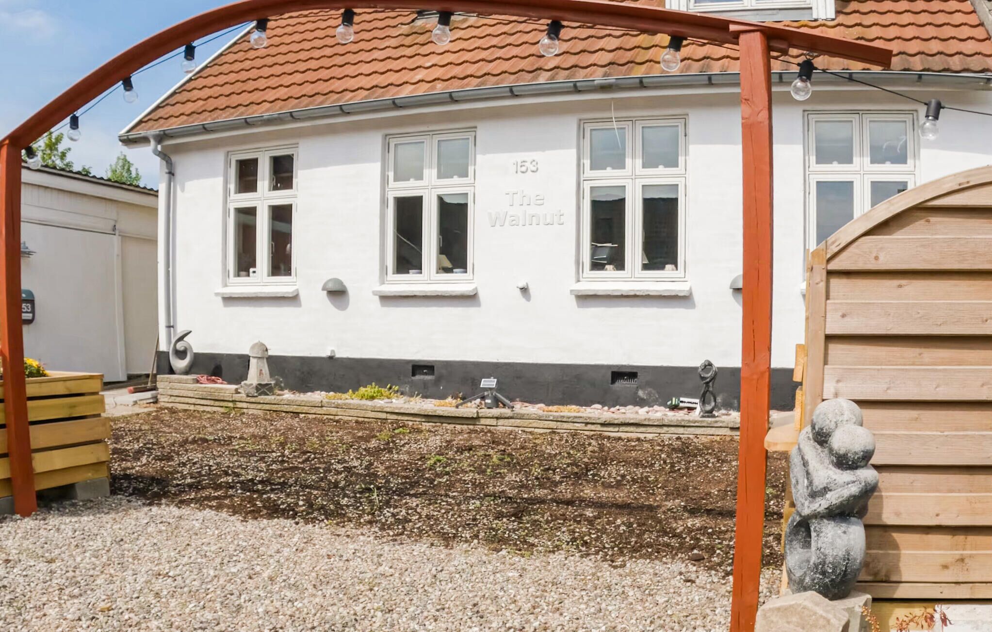 En hvid bygning med nummer 153 og navnet 'The Walnut' på facaden.
