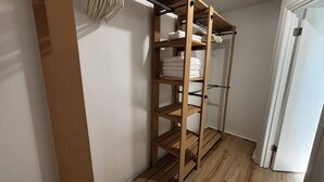 Een houten rek met opgevouwen handdoeken en een metalen stang in een gang.