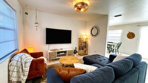 Een woonkamer met een televisie, bank, salontafel en een boekenplank.