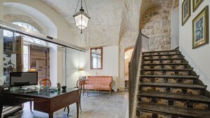 Quarto com escrivaninha, cadeira e escada com azulejos estampados.