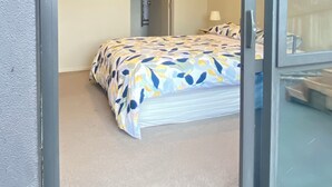 A bedroom with a bed, a door, and a window. - Fabulous residence in New Plymouth (New Plymouth)