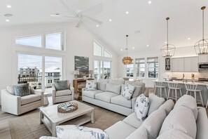 A spacious living area with a large sofa, armchairs, and a coffee table. There is a kitchen area with a dining table and chairs. - Southern Comfort, Navarre Beach FL (Navarre)