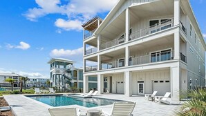 Un hôtel à plusieurs étages doté d’une piscine, de balcons et offrant une vue sur un ciel d’un bleu éclatant.
