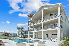 A multi-story hotel with a pool, balconies, and a clear blue sky. - Southern Comfort, Navarre Beach FL (Navarre)