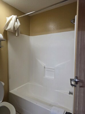 A bathroom with a bathtub, toilet, and a towel rack.