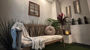 Ein Zimmer mit einer Holzbank, einem kleinen Fenster, Kunstgrasniveau und dekorativen Wandverkleidungen.