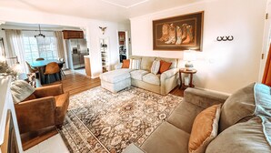A living room with a sofa, armchairs, a rug, and a dining area with a table and chairs. - Centrally Located, Family friendly Home- With Game Room and Infrared Sauna (Farmington)