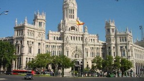 Un edificio grande y ornamentado con arquitectura clásica, que cuenta con múltiples torres y estatuas.