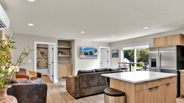 A modern kitchen with a central island, wooden cabinets, and a built-in refrigerator. - Pearl Loft • Downtown CDA (Coeur d'Alene)