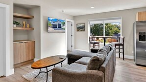 A modern living room with a sofa, coffee table, and dining area with chairs. - Pearl Loft • Downtown CDA (Coeur d'Alene)