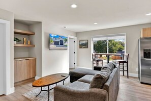 Ein stilvolles Wohnzimmer mit Sofa, Couchtisch und Essbereich mit Stühlen.