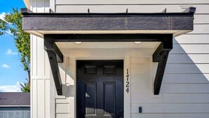 A modern house with a dark front door, a mailbox, and a welcome mat. - Pearl Loft • Downtown CDA (Coeur d'Alene)