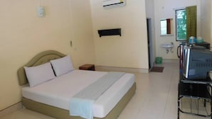 A hotel room with a bed, a desk, a chair, a sink, and an air conditioning unit. - 057 resort (Sikao)
