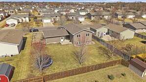 Un barrio residencial con varias casas, un patio cercado y un trampolín.