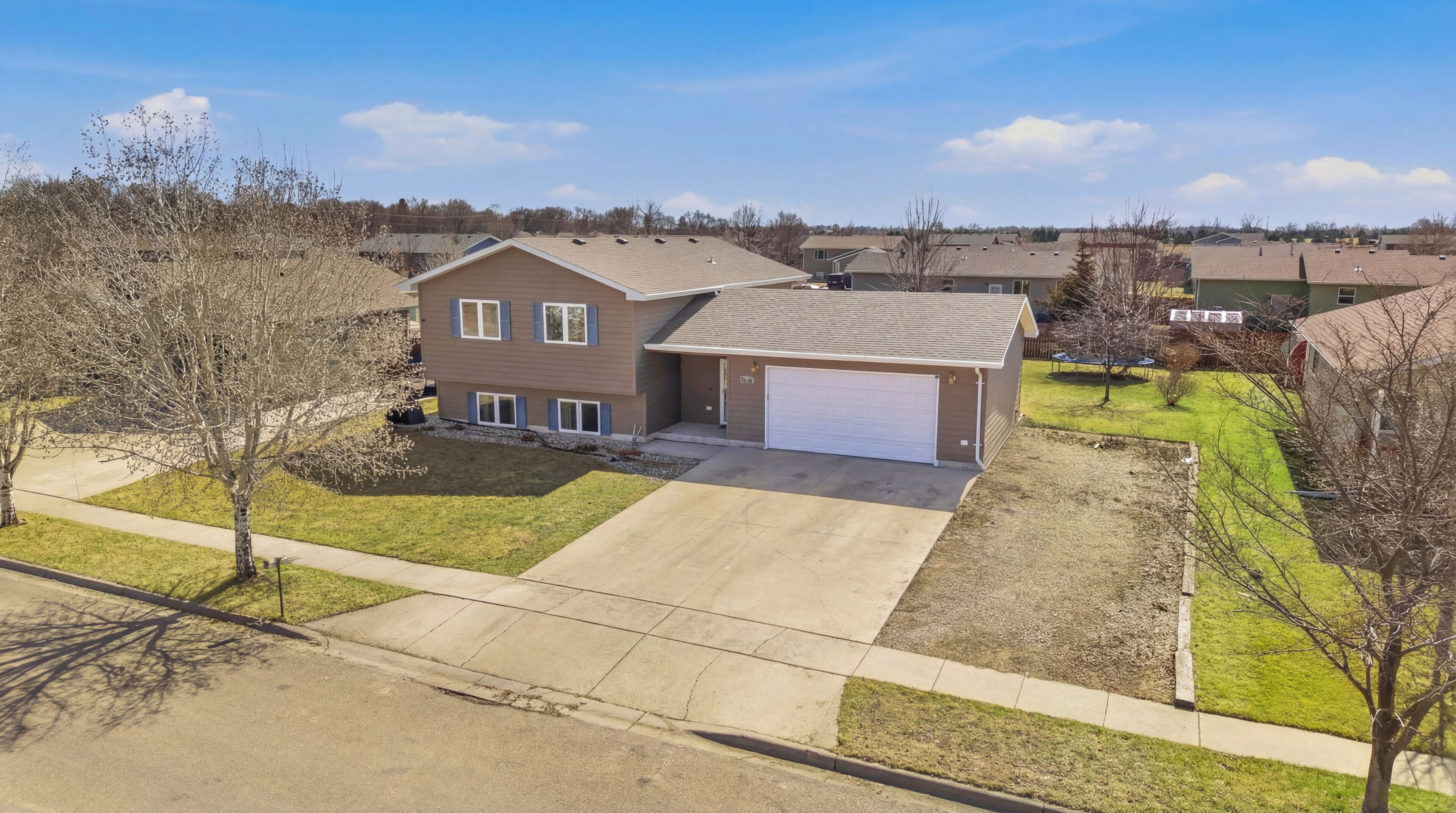 A two-story house with a garage, a driveway, and a well-maintained lawn.