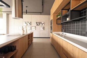 A modern kitchen with wooden cabinets, a white countertop, and black tiled backsplash. - Modern and cozy apartment in Larco Miraflores. (Miraflores)