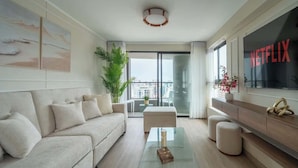 A modern living room with a sofa, coffee table, and a TV displaying 'NETFLIX'. - Largest & Elegant Apartment | Larco | Miraflores (Miraflores)