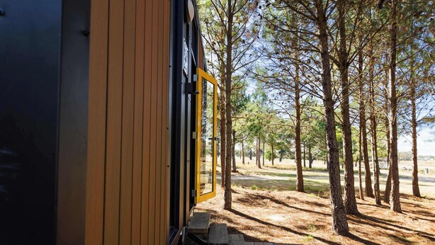 A wooden exterior with a glass door leading to a deck.