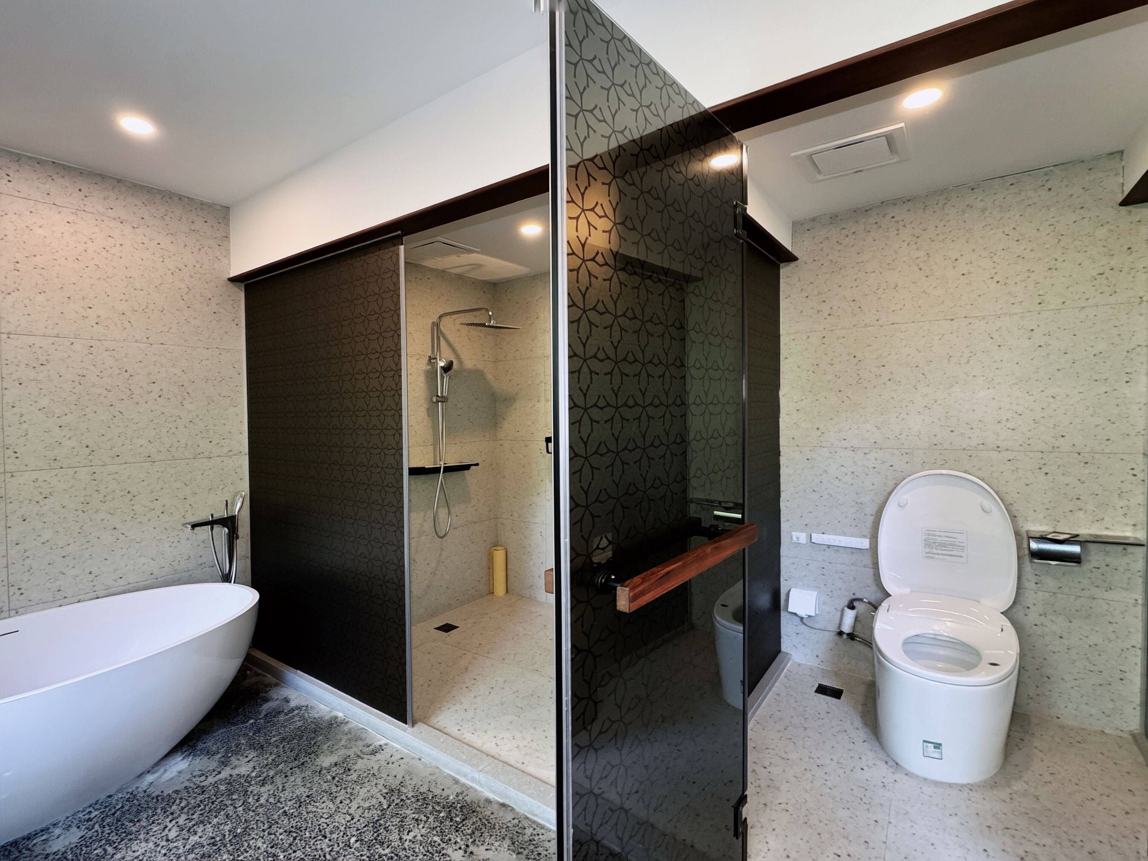 A modern bathroom with a freestanding bathtub, a glass-enclosed shower, and a toilet.