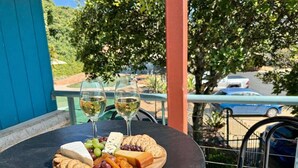 A table with a cheese board, grapes, crackers, and two glasses of white wine on a balcony. - Splash at Sapphire - Pet Friendly, Resort Pool, Beachfront (Coffs Harbour)