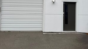 Un bâtiment doté d’une porte de garage, d’une petite porte et d’une fenêtre.