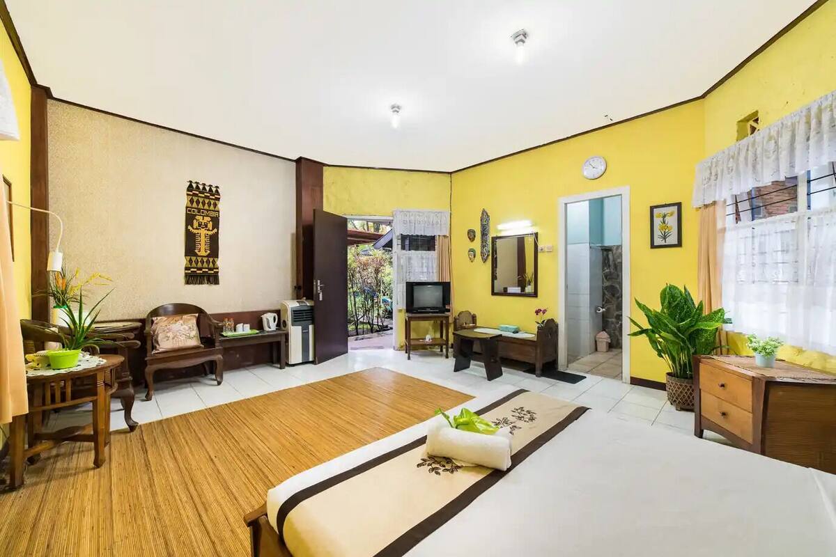 A hotel room with a bed, a desk, a chair, a TV, and a window.