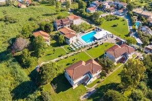 Vista aérea de un barrio residencial con casas, piscina y un amplio césped.