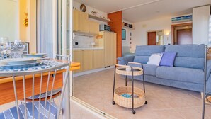 Ein kompakter Wohnbereich mit Essplatz, Küchenzeile und Sofa.