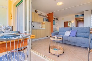 A compact living space with a dining area, kitchenette, and a sofa. - Residence Verdeblu, Capoliveri, Naregno (Capoliveri)