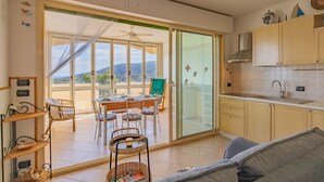Eine moderne Küche mit Essbereich, großen Fenstern und Blick ins Freie.