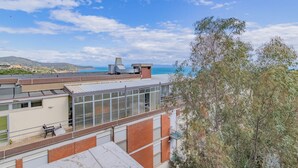 Ein Gebäude mit flachem Dach, großen Fenstern und Blick auf das Meer.
