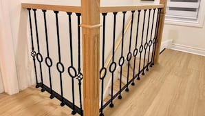 Une rampe d’escalier en bois et en métal, ornée d’un motif décoratif.