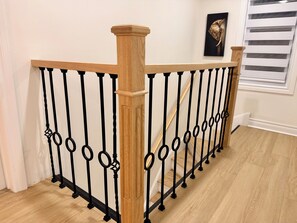 Une rampe d’escalier en bois et en métal, ornée d’un motif décoratif.