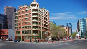 Un hotel de diverses plantes amb una cúpula característica i balcons, envoltat d'edificis moderns.