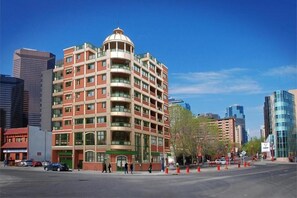 A multi-story hotel with a distinctive dome and balconies, surrounded by modern buildings.