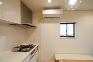 A kitchen with a stove, pots, a window, and an air conditioner. - 【5BR Luxury Living】 130㎡DesignerHouse-5BR Luxury Living, Family Roppongi Akasaka (Tokyo)