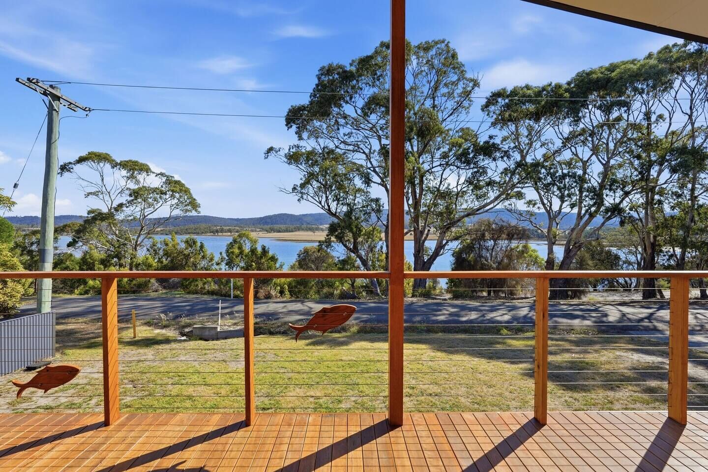 A balcony with a view of a lake and trees.
