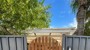 A gated entrance with a wooden gate, a metal gate, and a number '1' sign. - Coastal Retreat with Private Verandah -
King Bed - Walk to Beach & Train (Adelaide)