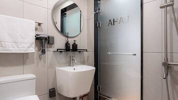 Deluxe vierpersoonskamer | Badkamer | Een douche, een haardroger, handdoeken, shampoo