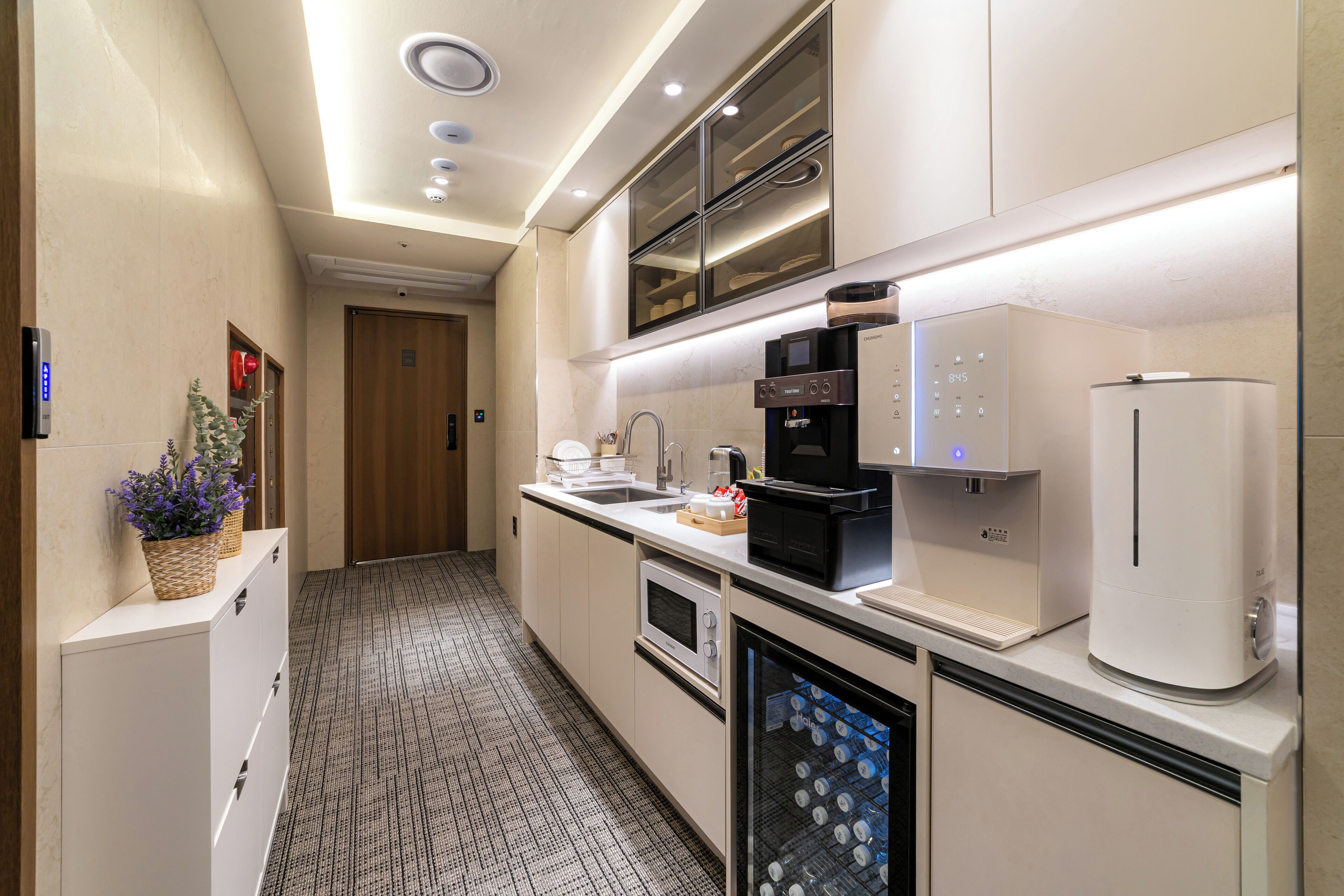 Une cuisine moderne équipée d’un four à micro-ondes, d’une machine à café et d’un réfrigérateur.